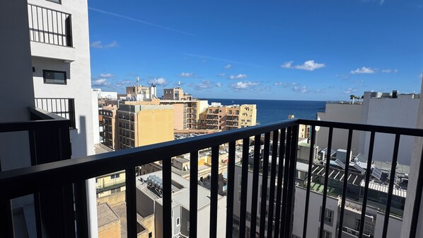 A high-rise building with a balcony overlooking a cityscape and the sea. - Aste Hotel (St. Julian's)