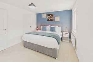 A bedroom with a bed, bedside tables, a radiator, and artwork on the wall. - Host Stay Clearwell Gardens (Cheltenham)