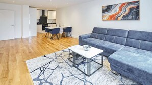 A modern living room with a grey sofa, a white coffee table, and a blue patterned rug. - Host Stay Eton House (Windsor)