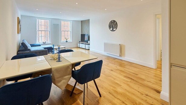 A modern living room with a dining area, wooden flooring, and a television in the background. - Host Stay Eton House (Windsor)