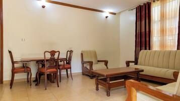 Una sala de estar con una mesa de comedor, sillas, un sofá y una mesita de centro.
