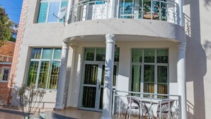 A multi-story building with a curved facade, large windows, and a balcony with white railings. - Atlas Residence (Kigali)