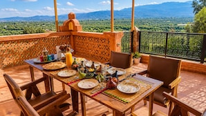 A wooden table set for breakfast with a view of mountains. - Luxurious Aghmat Villa With Private Pool and Panoramic Mountain Views (Ourika)