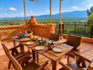 A wooden table set for breakfast with a view of mountains. - Luxurious Aghmat Villa With Private Pool and Panoramic Mountain Views (Ourika)