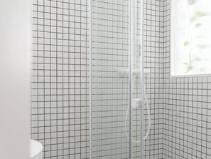 Chuveiro, toalhas de banho, sabonete, papel higiênico