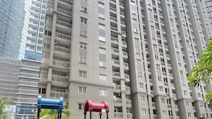 A playground with slides and swings, surrounded by tall residential buildings.