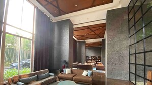A modern living room with a large sofa, a coffee table, and a bookshelf.