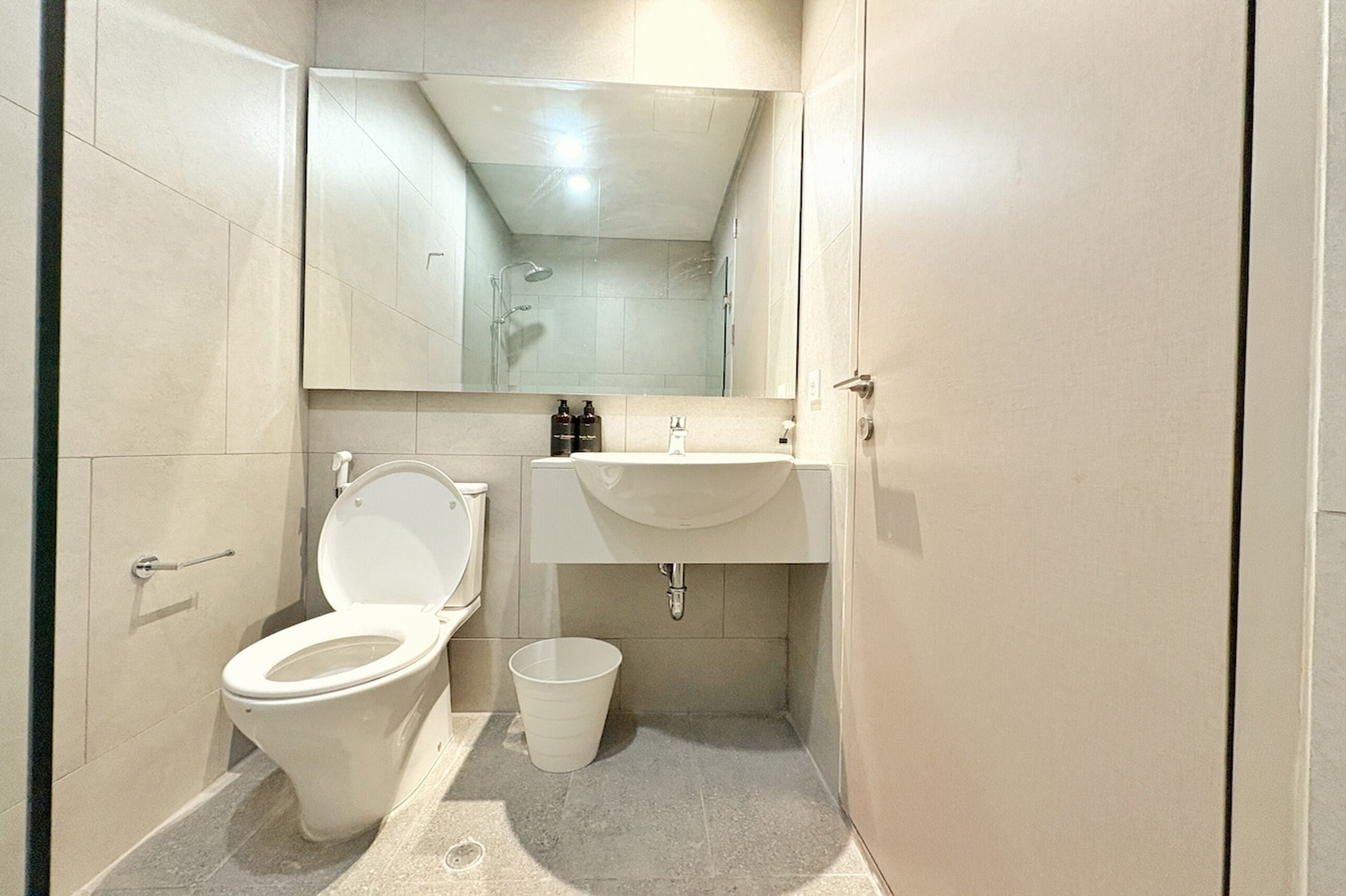 Un baño pequeño con inodoro, lavamanos y espejo.