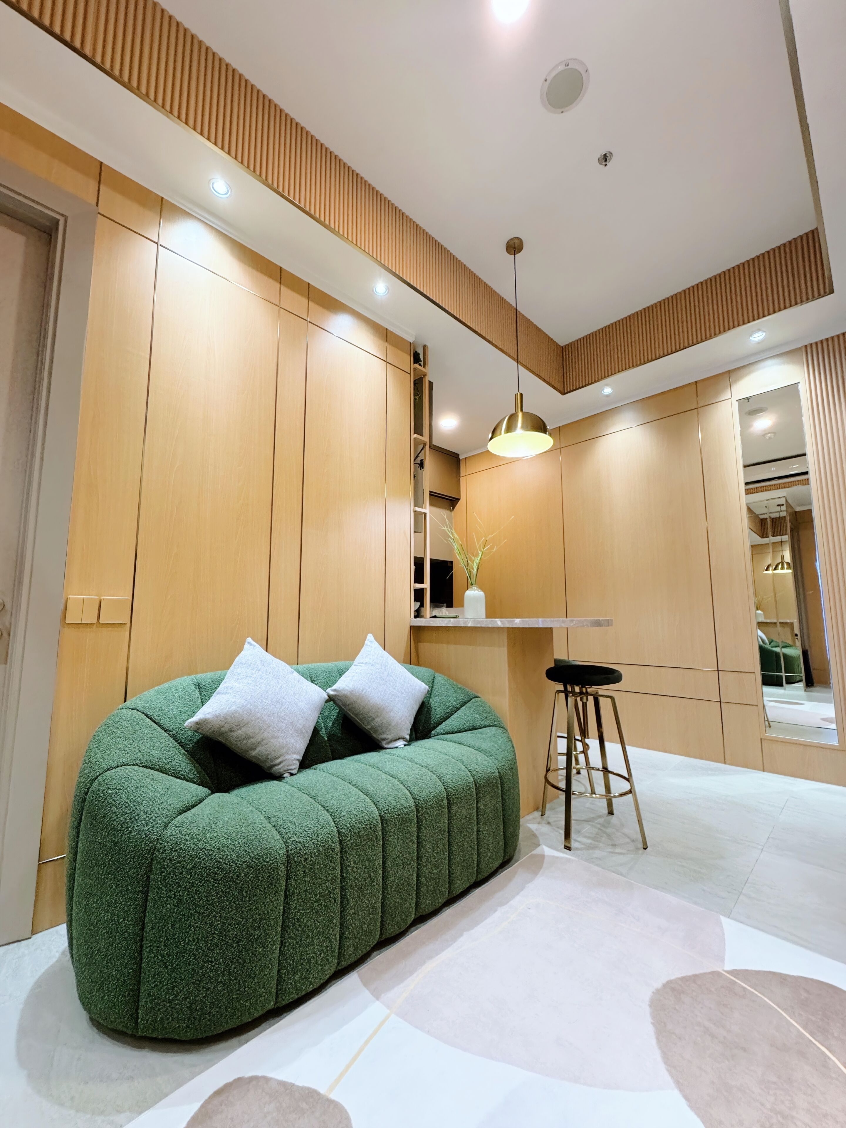 Une chambre moderne avec un fauteuil en forme de haricot vert, des murs recouverts de panneaux en bois et un petit coin bar.