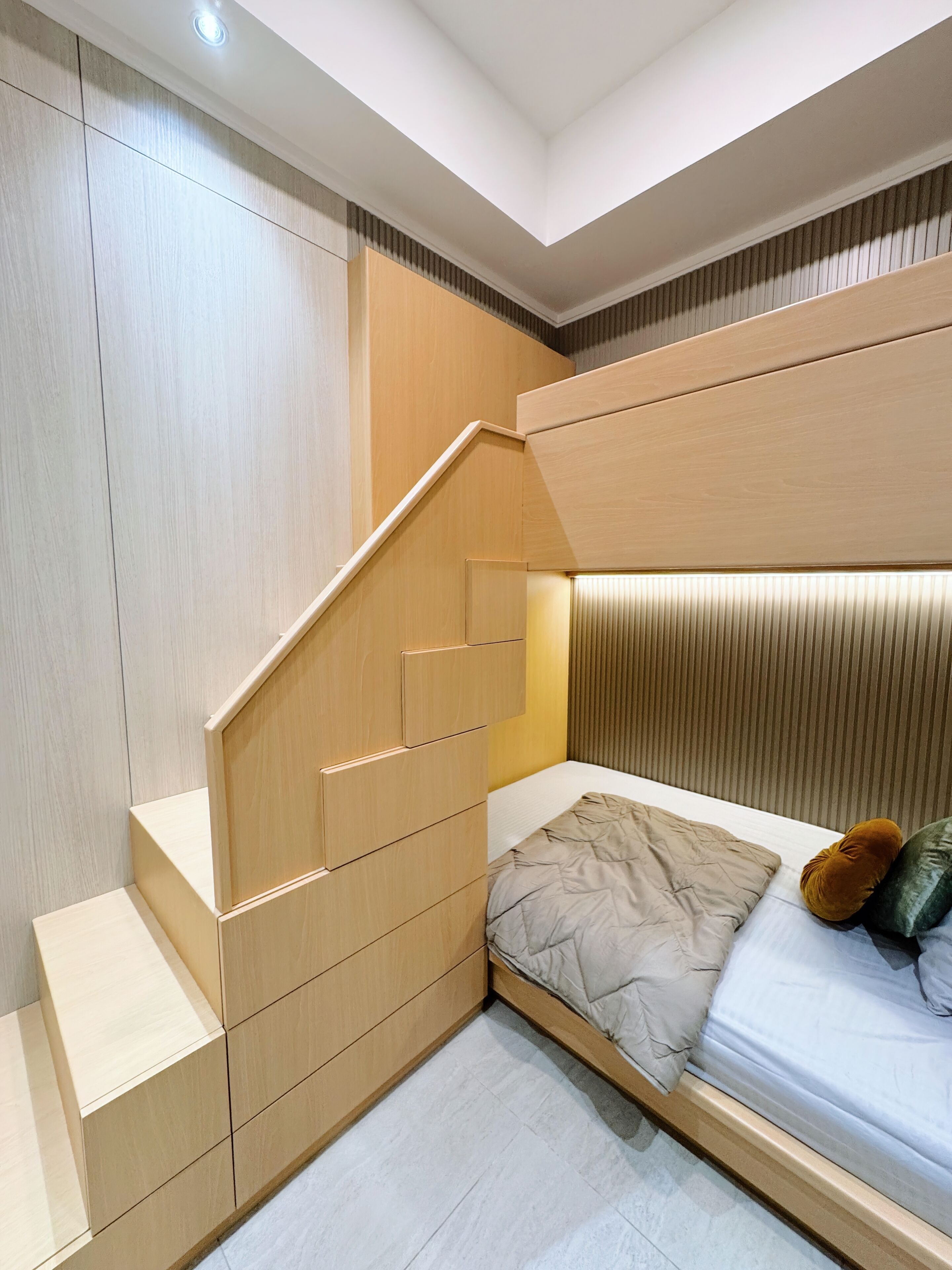 A modern bedroom with a built-in bed, wooden wardrobe, and a staircase.