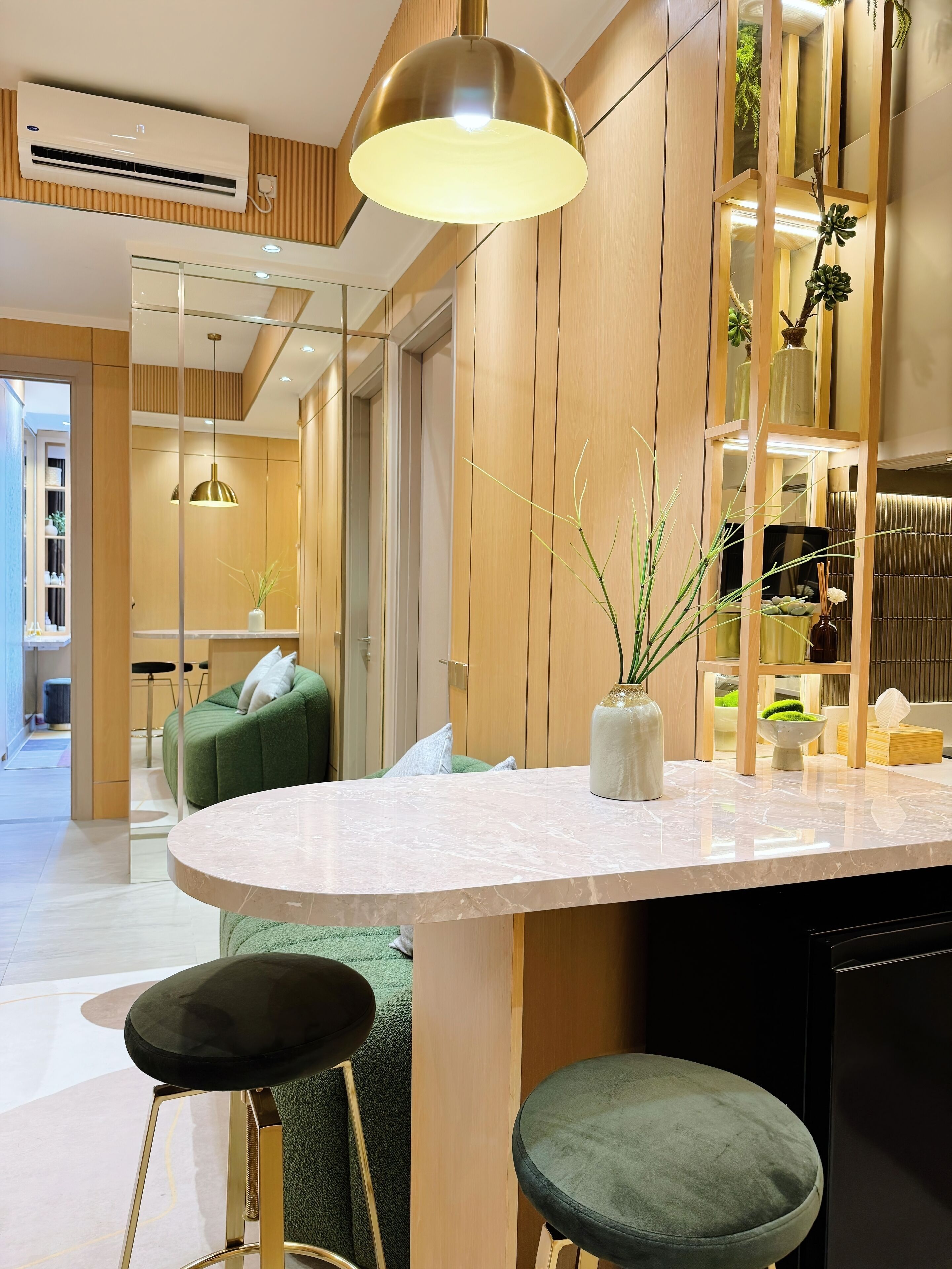 A modern kitchen with a marble countertop, two stools, and a pendant light.