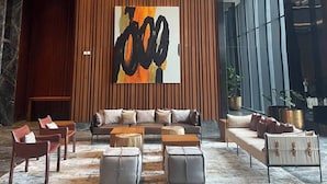A modern lobby with a large abstract painting, a seating area with sofas and ottomans, and a marble floor. - Premium Luxury Menara Jakarta Residence (Jakarta)