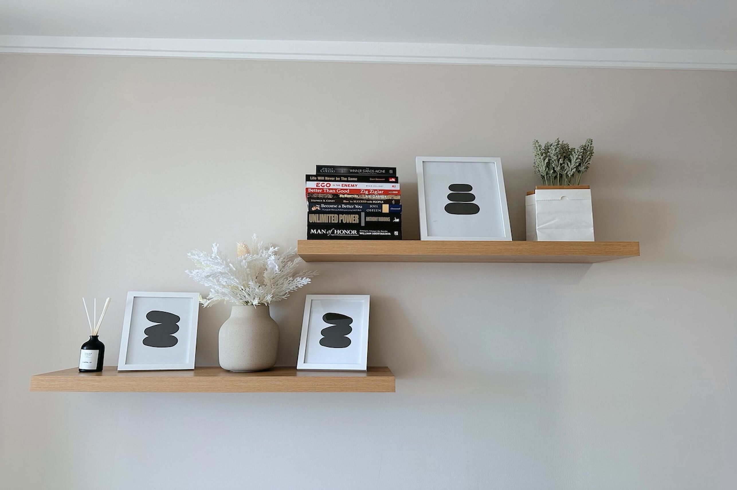 Two wooden shelves with books, decorative items, and a small plant.