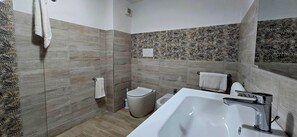 A modern bathroom with a bathtub, toilet, and shower area. - Resident Albachiara, Your Oasis in Castelsardo (Castelsardo)