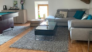 A modern living room with a pool table, a sofa, and a coffee table. - Billiards Lounge loft with Billiards & Netflix by BoookingFuté (Socourt)