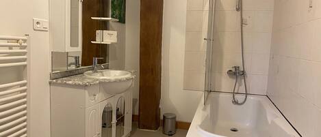 Un baño con lavamanos, espejo y ducha.