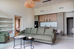 Ein modernes Wohnzimmer mit einer Couch, einem Couchtisch und einem Essbereich mit einem Stuhl.