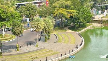 A riverside park with a curved walkway, trees, and a McDonald's restaurant in the background.