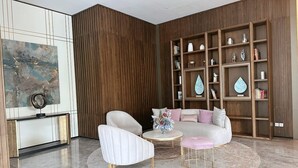 A modern living room with a sofa, two armchairs, a coffee table, and a console table with decorative items.