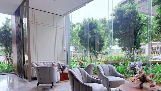 A modern interior with a seating area, a round wooden table, and a view through large windows.