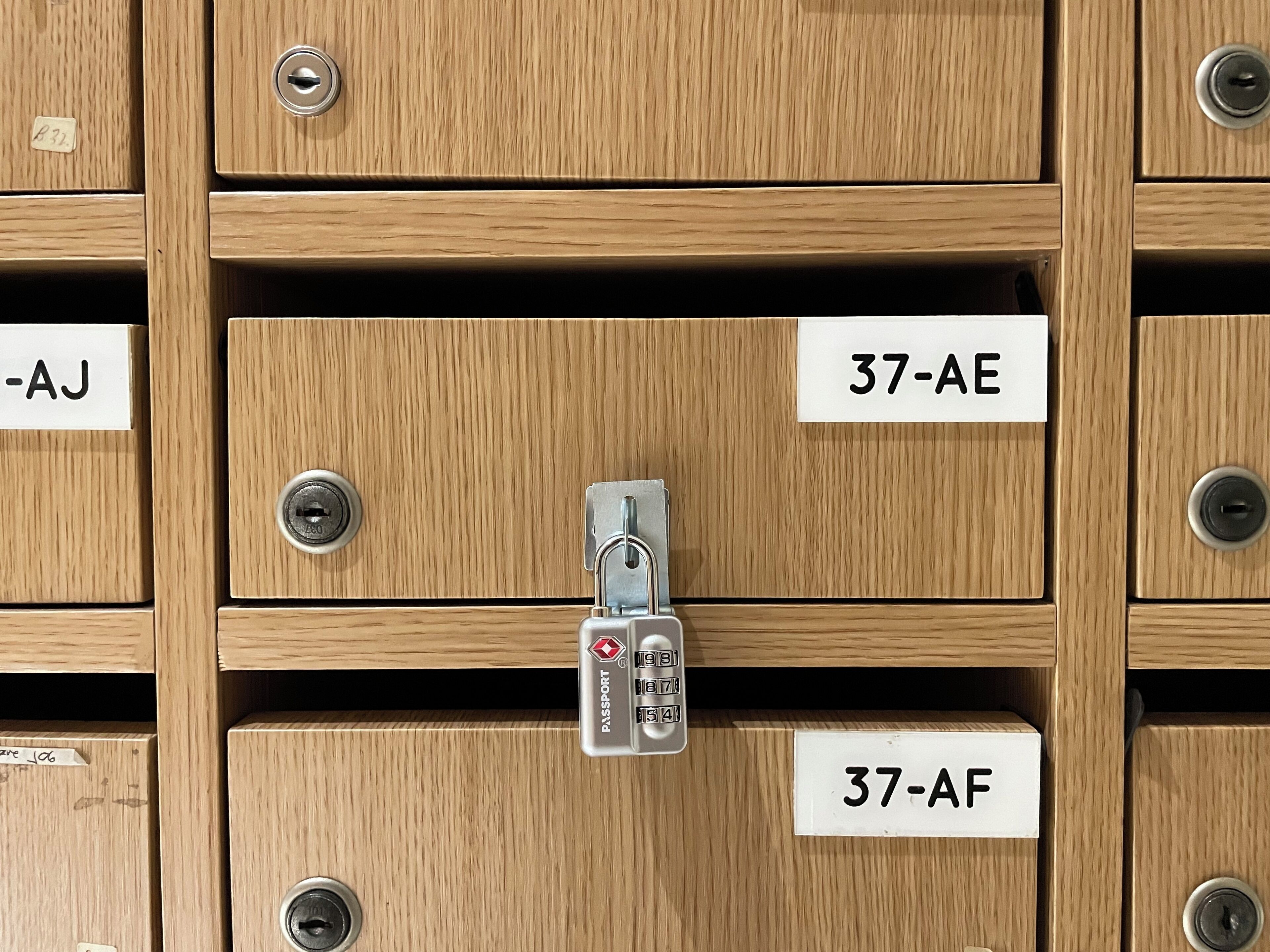 A row of wooden storage boxes with metal locks, each labeled with a unique identifier.
