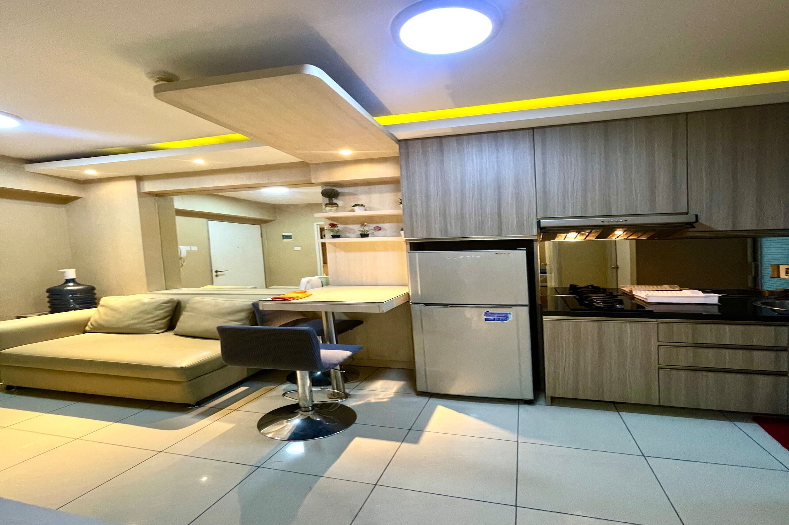Un espacio habitable pequeño con kitchenette, un sofá y un comedor.