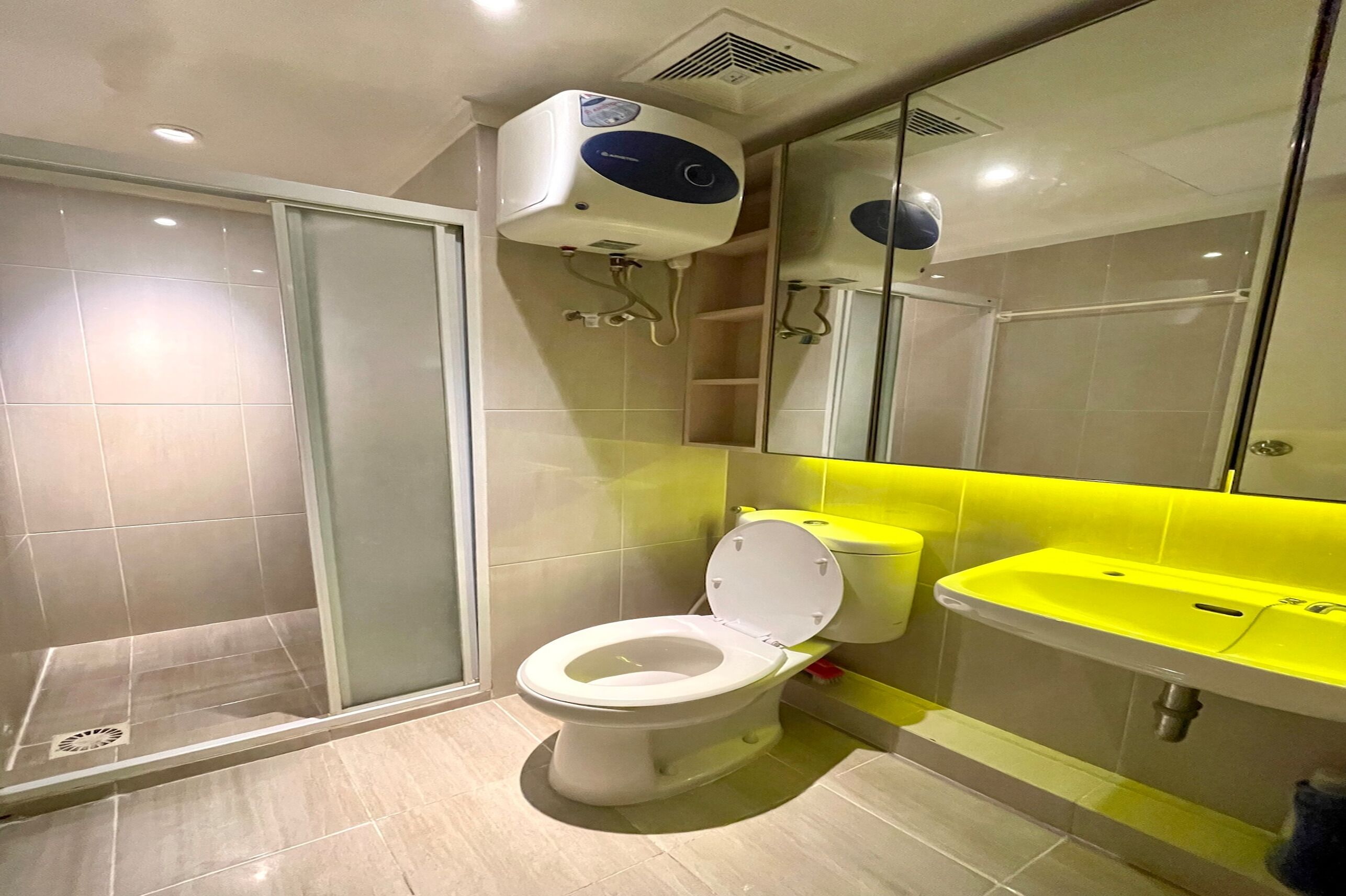 A modern bathroom with a toilet, shower, and sink.