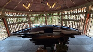 A conference room with a round table, chairs, and a laptop.
