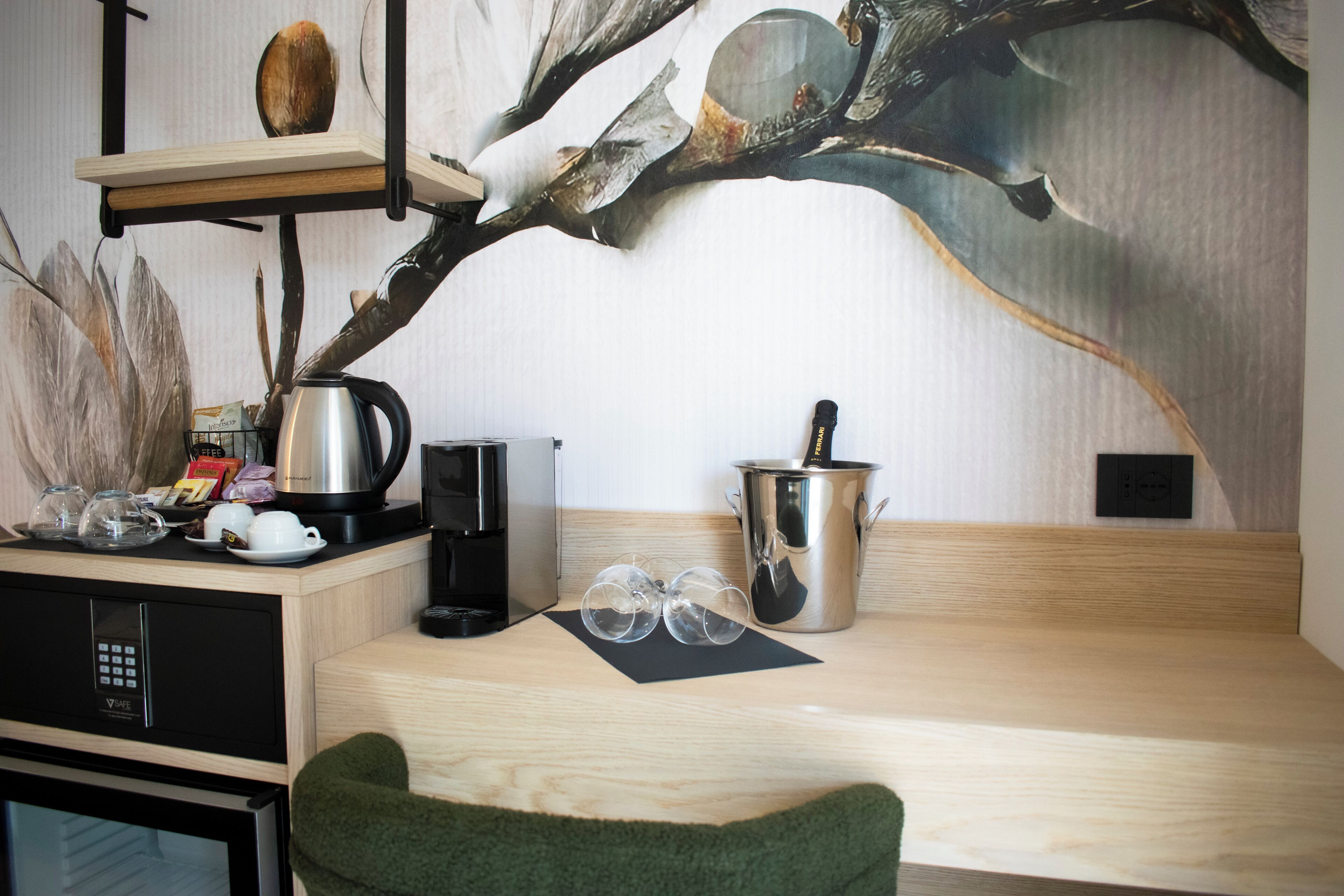 A kitchen area with a coffee maker, kettle, and a pot on the counter.