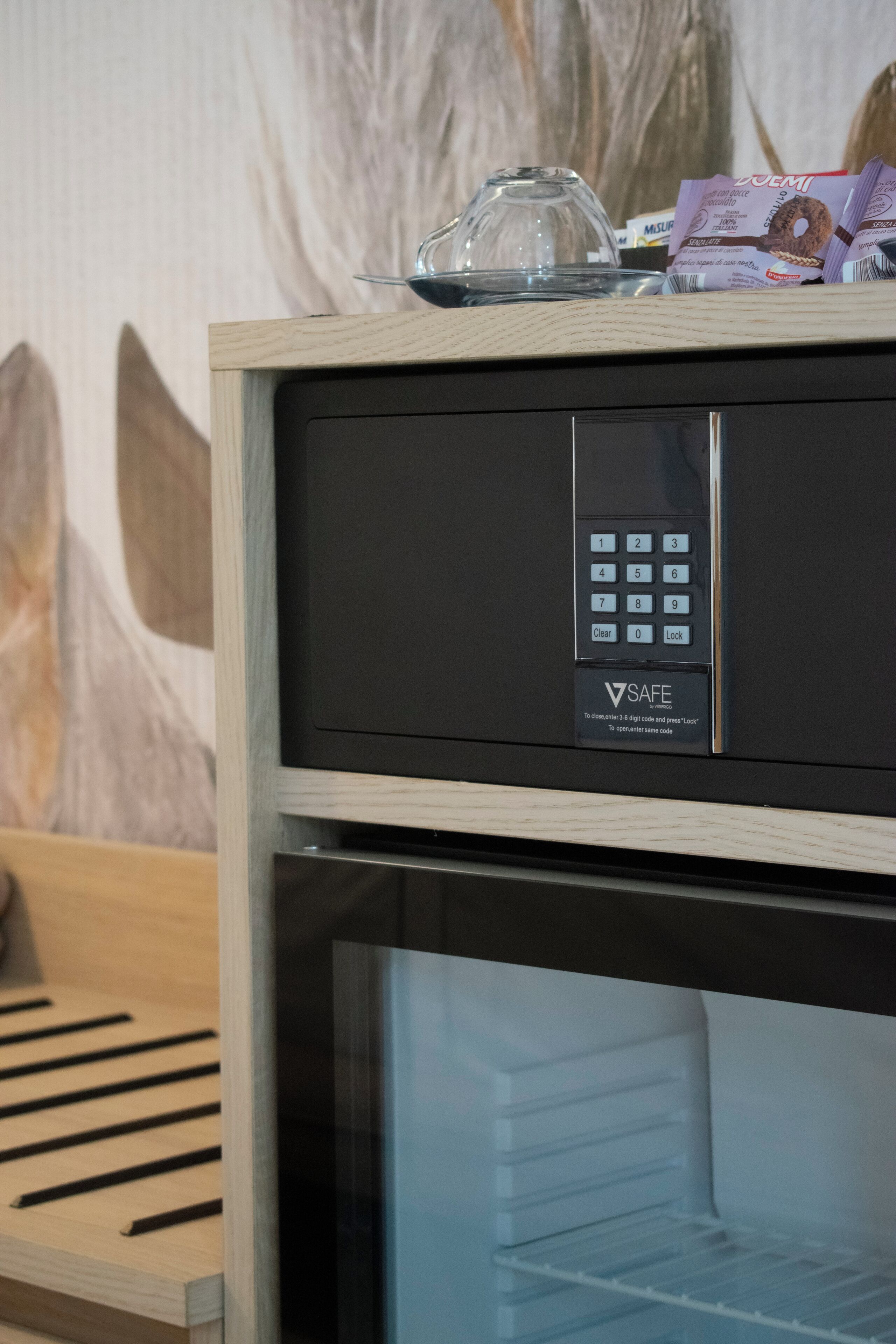 Un mini-bar doté d’un verrou numérique, d’un couvercle en verre et d’une pile de barres de chocolat.