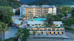 A multi-story hotel with a pool, surrounded by lush greenery and mountains. - Fullman Hotel (Luang Prabang)