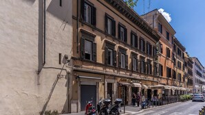 Una hilera de edificios tradicionales europeos con ventanas con contraventanas y una calle adoquinada.