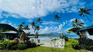 A tropical resort with a pool, palm trees, and a view of the ocean. - Sublime Tahiti Beach Retreat (Teva I Uta)