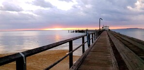 A wooden pier extending into calm waters with a sunset in the background. -  Banksia Hideaway – Paradise Awaits - K’gari (Fraser Island) (K'gari)