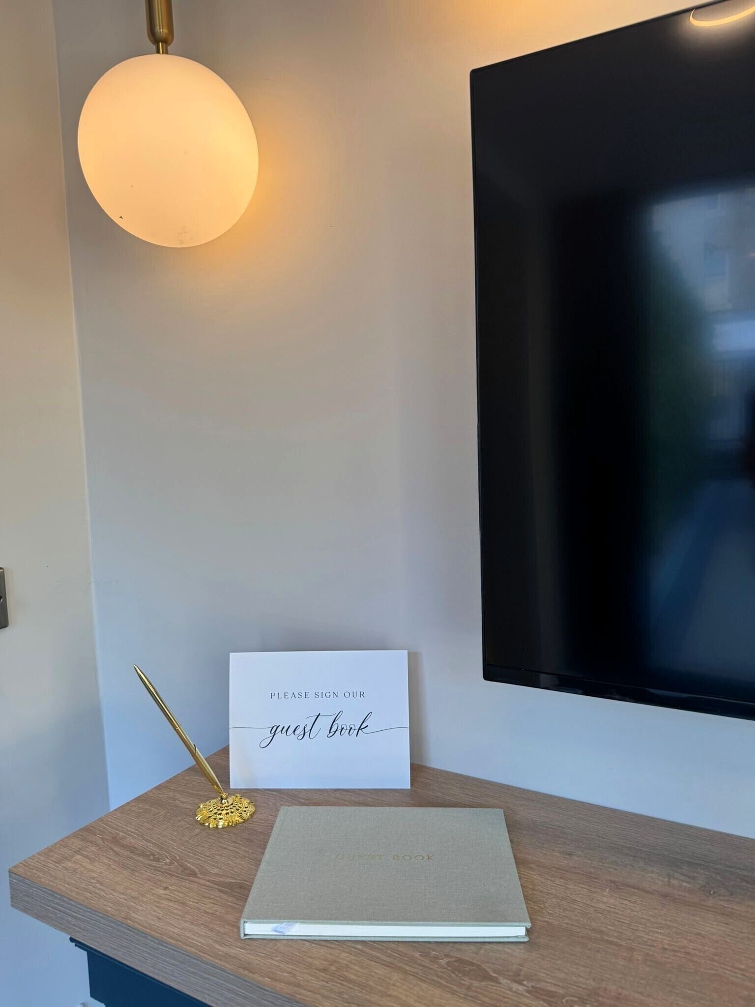 Ett skrivbord med en gästbok, en penna och ett anteckningsblock.