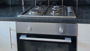 Cuina amb fogó a gas, forn i saló volàtil negre.
