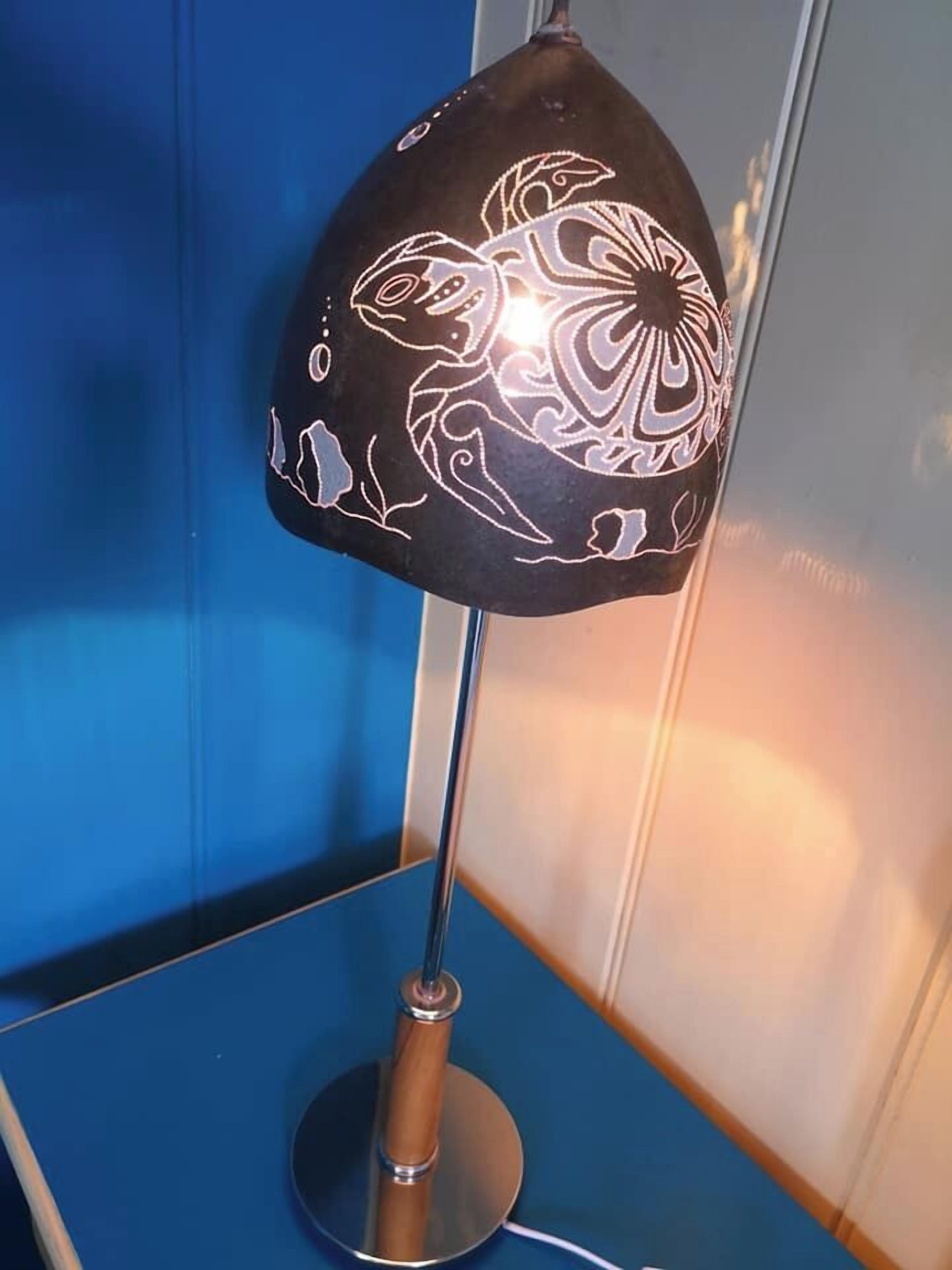 Eine Tischlampe mit einem dekorativen Design am Lampenschirm.