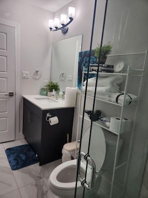 A modern bathroom with a toilet, sink, and shower area.
