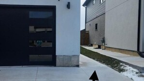 A modern building with a garage and a large driveway. - Gateway to Serenity-welcome Home (London)