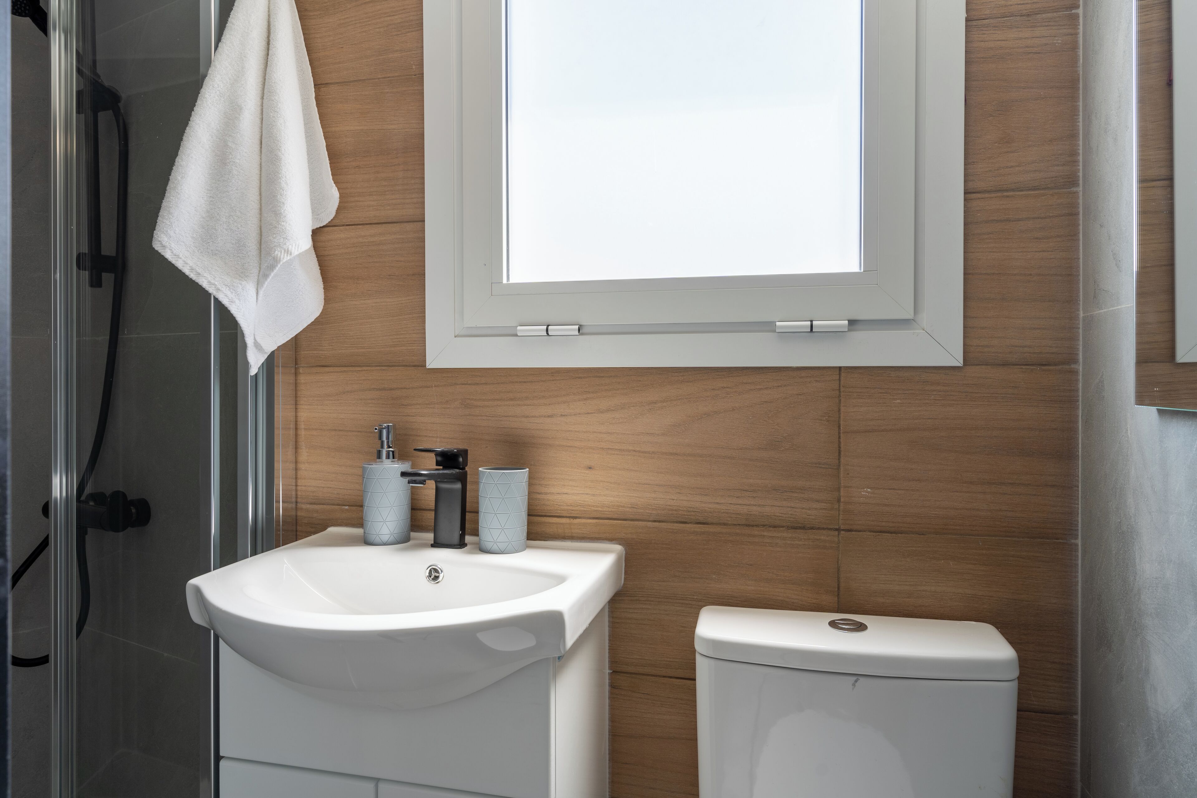 A bathroom with a white sink, a toilet, and a shower.