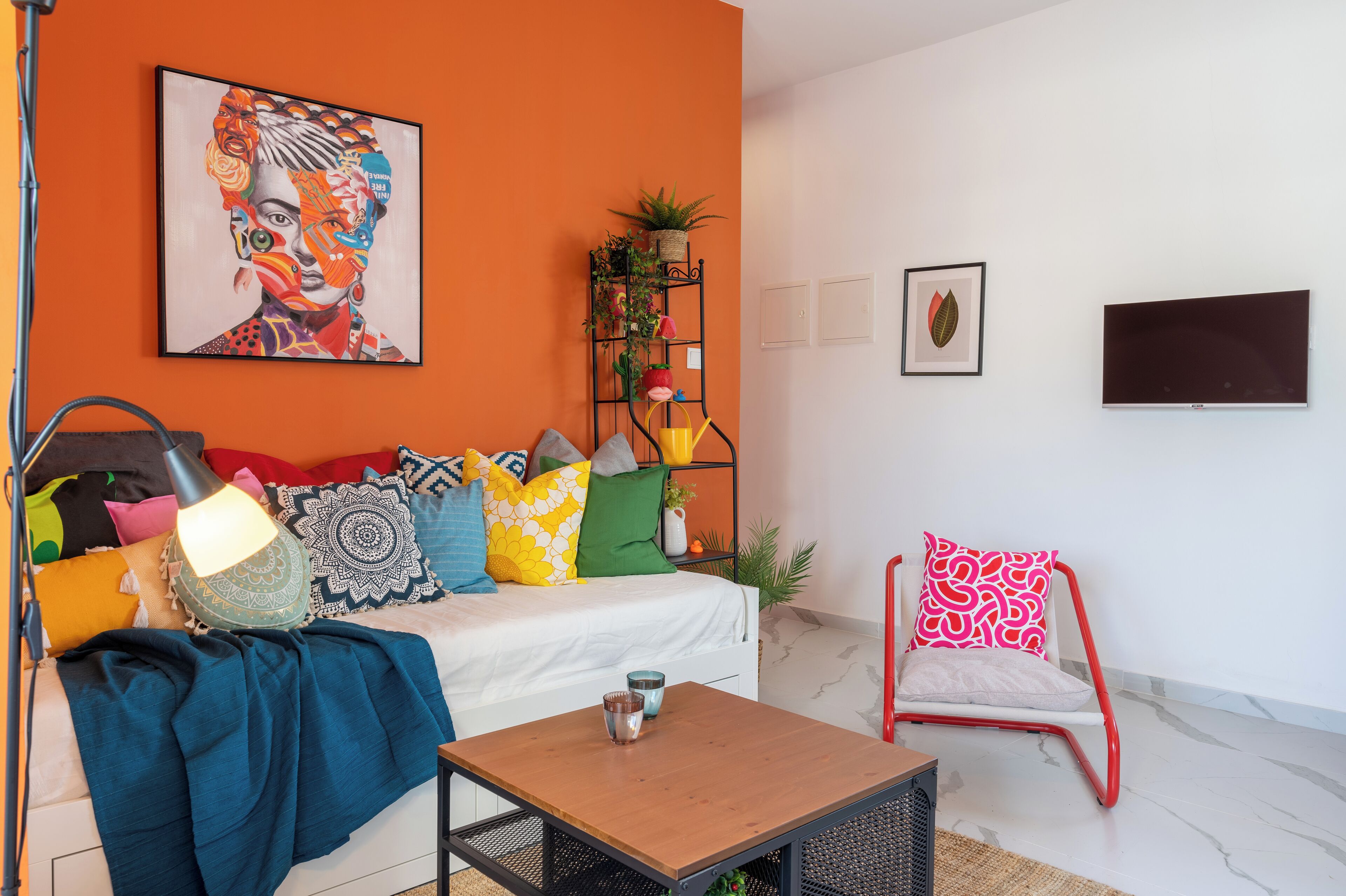 A living room with a sofa, coffee table, and a TV mounted on the wall.