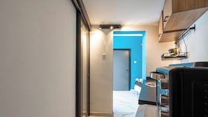 Eine moderne Küche mit Marmorarbeitsplatte, schwarzen Geräten und einer blauen Akzentwand.