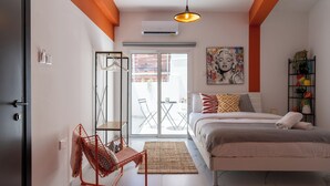 Ein modernes Schlafzimmer mit einem Bett, einem Sessel, einem großen Fenster und einem Gemälde an der Wand.