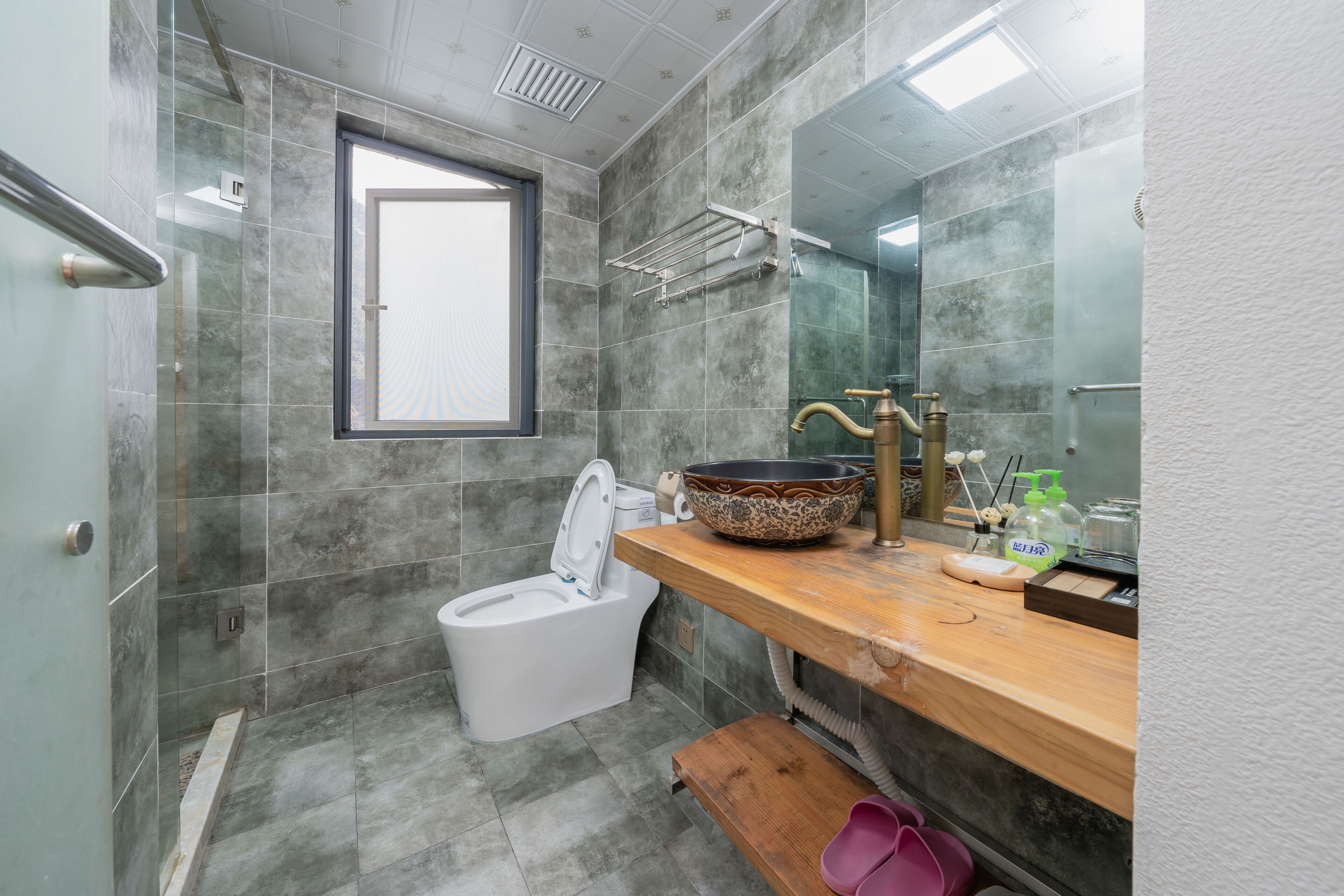 Un baño con inodoro, lavabo, espejo y ventana.