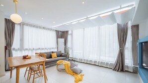 Una sala moderna con una mesa de comedor, un sofá y un televisor.