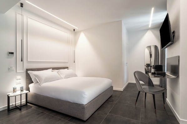 Un dormitorio moderno con una cama grande, una mesita de noche y una silla.