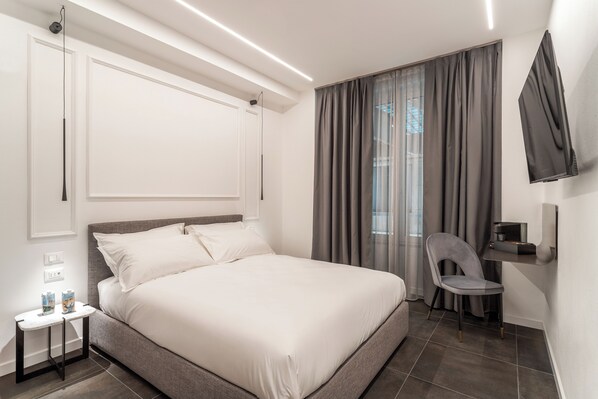 Una habitación de hotel moderna con una cama grande, un escritorio y una silla.