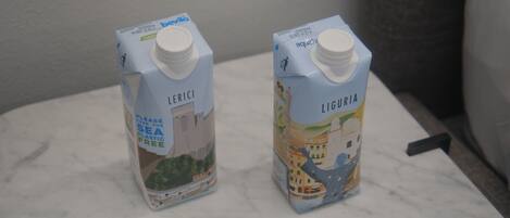 Two cartons of milk on a marble countertop.