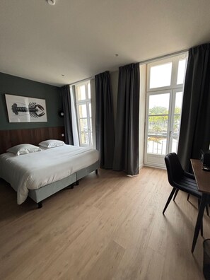 A hotel room with a bed, a desk, and a window with curtains. - Hotel Hermine Vannes Port de Plaisance (Vannes)
