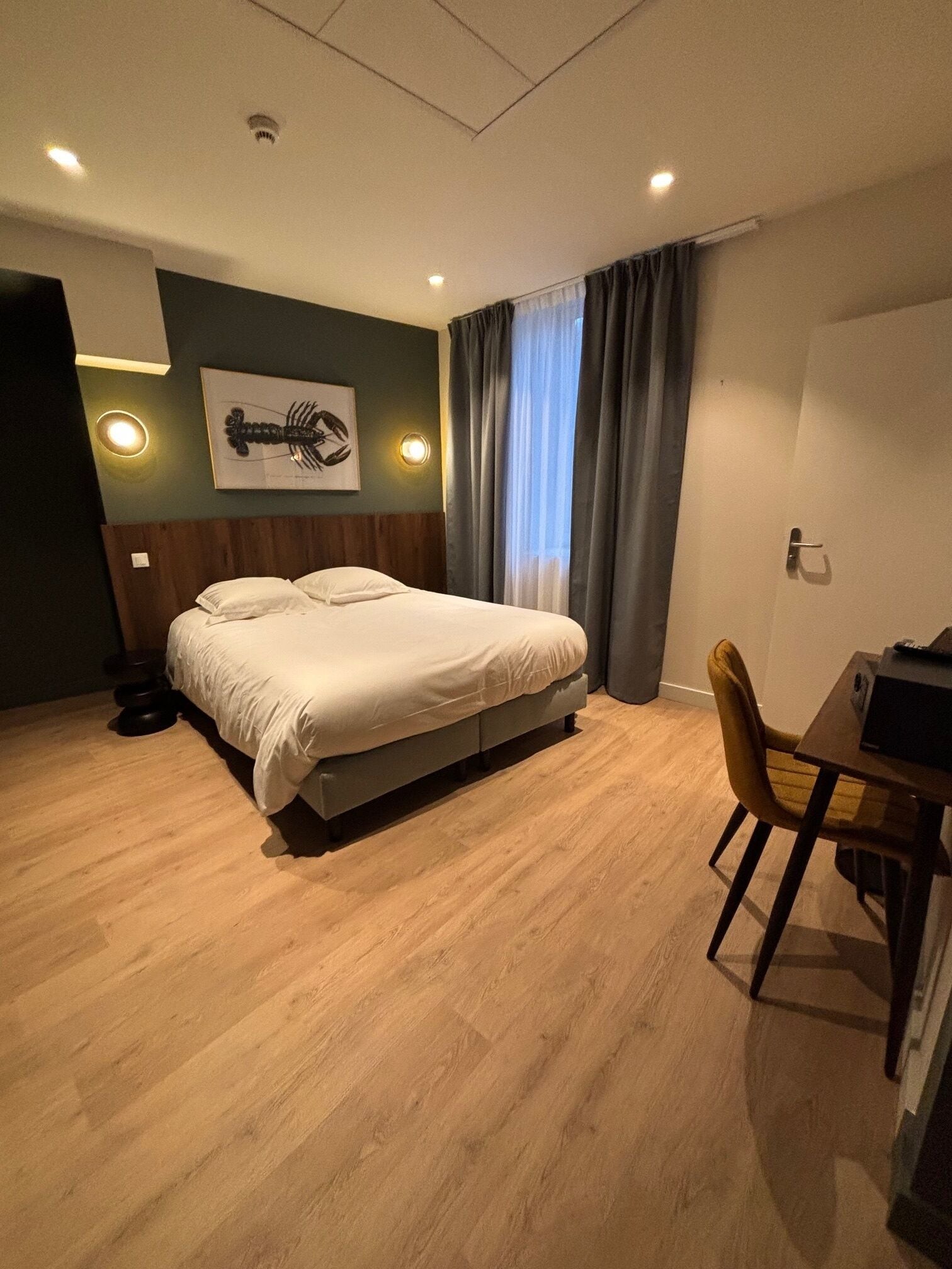 A hotel room with a bed, a desk, and a chair.